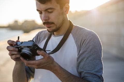 Young man looking at camera on waterfront promenade at the riverside model released Symbolfoto  VPIF01053