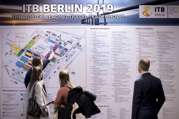 ITB travel fair Berlin Deu, Deutschland, Germany, Berlin, 07.03.2019 Besucher und Haendler am Stand vor einem Plan auf der Internationalen Tourismusboerse ITB in Berlin. Ueber 10.000 Ausstellern aus 181 Laendern praesentieren die neuesten Trends zum Thema Reisen, Tourismus und Urlaub auf der ITB. Visitor and trader at a exhibition hall with map during the ITB International Travel Trade Fair in Berlin, Germany. The travel trade show will be running from March 6 to 10, 2019 and includes about 10.000 exhibitors from 181 countries and regions who present their products during the fair in the German capital