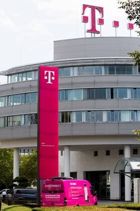 Firmenlogo der deutschen Telekom am Hauptsitz in Bonn, Firmenfahrzeug als Werbeträger für modernstes Mobilfunknetz - Company logo of the German Telekom at the headquarters in Bonn, company vehicle as an advertising medium for the most modern mobile network