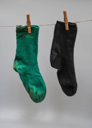 Eine grüne und eine schwarze Socke hängen an einer Wäscheleine. In Baden-Württemberg bilden Grüne und Schwarze die Landesregierung. Foto:Winfried Rothermel