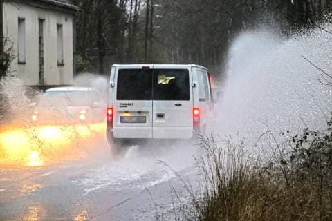 Gefährliche Straßenverhältnisse bei Starkregen. Das Wasser von einer nach Starkregen überfluteten Straße wird von den Autos in die Luft gerissen und sorgt bei vielen Fahrern für Schrecksekunden. Essen Nordrhein-Westfalen Germany - Deutschland Überruhr