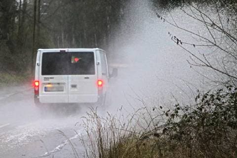 Gefährliche Straßenverhältnisse bei Starkregen. Das Wasser von einer nach Starkregen überfluteten Straße wird von den Autos in die Luft gerissen und sorgt bei vielen Fahrern für Schrecksekunden. Essen Nordrhein-Westfalen Germany - Deutschland Überruhr