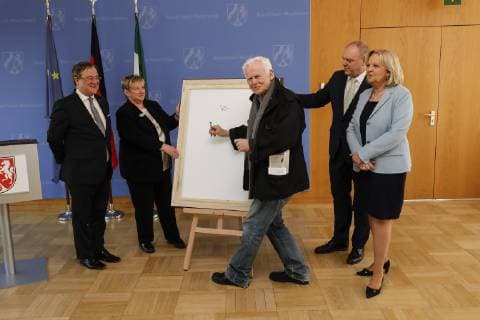 22.03.2019. Ministerpräsident Armin Laschet (li.) freut sich, gemeinsam mit Ministerpräsidentin a.D. Hannelore Kraft das neue Porträtbild der ersten Regierungschefin Nordrhein-Westfalens vorzustellen. Ministerpräsidentin a.D. Hannelore Kraft (re.) wird in der Galerie mit einer Fotografie des Fotokünstlers Jim Rakete (mi.) dargestellt. Düsseldorf Staatskanzlei Nordrhein-Westfalen Deutschland