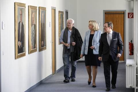 22.03.2019. NRW-Ministerpräsident Armin Laschet (re.) freut sich, gemeinsam mit Ministerpräsidentin a.D. Hannelore Kraft (mi.) das neue Porträtbild der ersten Regierungschefin Nordrhein-Westfalens vorzustellen. Ministerpräsidentin a.D. Hannelore Kraft wird in der Galerie mit einer Fotografie des Fotokünstlers Jim Rakete (li.) dargestellt. Düsseldorf Staatskanzlei Nordrhein-Westfalen Deutschland