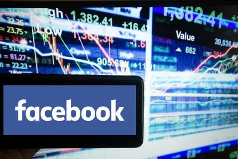 FOTOMONTAGE Wertvollste Unternehmen, Das Logo von Facebook ist auf einem Bildschirm von einem Handy neben einer Illustration des schnelllebigen Aktienmarkts zu sehen. New York State USA NYSE *** Most valuable company The logo of Facebook can be seen on a screen of a mobile phone next to an illustration of the fast moving stock market New York State USA NYSE