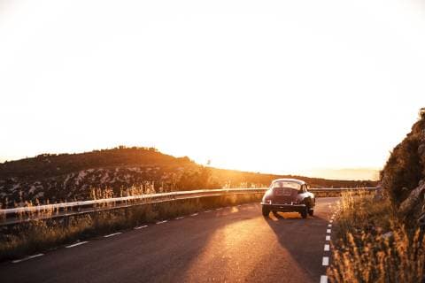 Spain, classic car driving on road during sunset  ACPF00394