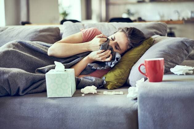 Sick woman trying to take a nap while lying on couch covered in blanket model released Symbolfoto property released  BSZF00896