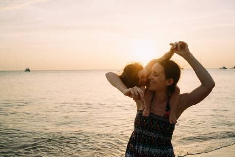 Thailand, Koh Lanta, happy mother with baby girl on her shoulders at seashore during sunset model released Symbolfoto  GEMF02658