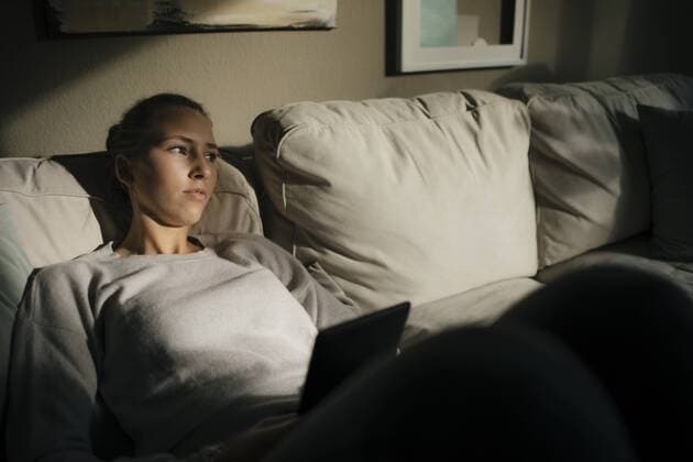 Serious teenage girl with tablet sitting on couch at home model released Symbolfoto property released  JOSF02939