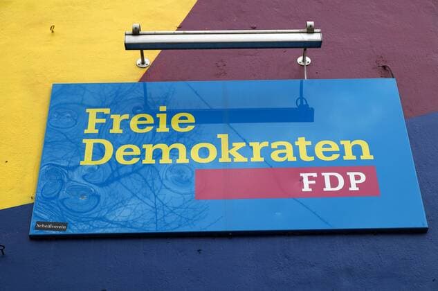 Das Partei-Logo der Freien Demokraten am Bremer FDP-Haus. Das Parteigebäude ist in den Parteifarben gestrichen. Ein Parteigegner hat das Schild mit einem Aufkleber versehen: Scheißverein.