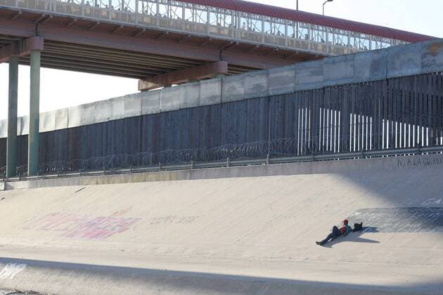 April 14, 2019 - Juarez-El Paso, Mexico - Man rests under the wall that divides Mexico from United States on the side of the international bridge..at the border City Juarez-El paso Texas on 14 April 2019. Juarez-El Paso Mexico  - ZUMAn230 20190414_zaa_n230_871 Copyright: xDavidxPeinadox
