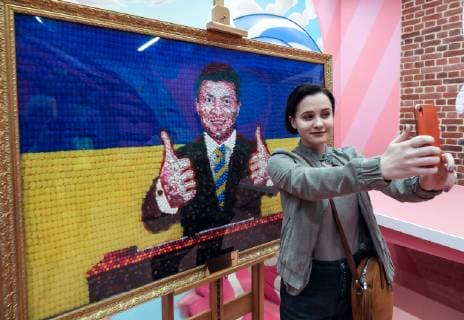 ST PETERSBURG, RUSSIA - APRIL 18, 2019: A visitor takes a selfie at a 15kg picture showing a likeness of Ukraine s presidential candidate Volodymyr (Vladimir) Zelensky with the national Ukrainian colours behind, made from some 3,000 Roshen sweets, at Sladky (Sweet) Museum at Nevsky Prospekt in St Petersburg; Roshen is a confectionery corporation owned by Ukraine s incumbent president Poroshenko who is also taking part in the 2019 Ukrainian presidential election. Alexander Demianchuk TASS  TS0A8A18