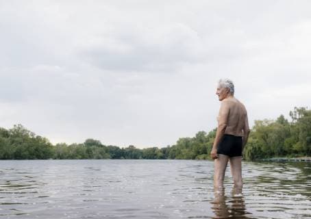 Senior man standing in a lake model released Symbolfoto  GUSF01790