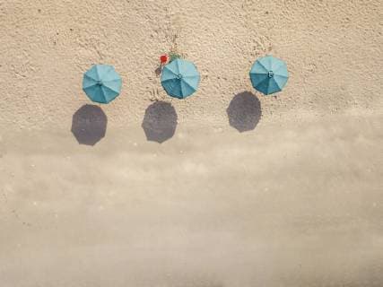 IMAGO Creative, Jahreszeit Sommer, Sonnenschutz Bali, Kuta Beach, three beach umbrellas, aerial view  KNTF02499