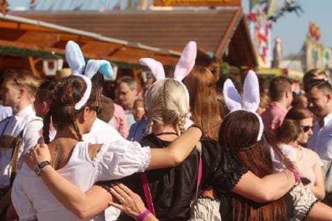 Cannstatter Wasen Frühlingsfest am Ostersonntag in Stuttgart Bad Cannstatt, Baden Württemberg, Deutschland: Frauen im bayerischen Dirndl tragen zum Osterfest passende Hasenohren auf dem Kopf.