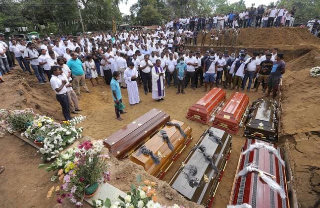 News Themen der Woche KW17 News Bilder des Tages April 24, 2019 - Colombo, Sri Lanka - Coffins are laid for burial as a Sri Lankan catholic priest surrounded by devotees and family members of the victims carry out religious rituals during a mass burial for Easter Sunday Church bomb blast victims in Negombo, Sri Lanka, Wednesday, 04- 24-2019. Colombo Sri Lanka  - ZUMAn230 20190424_zaa_n230_083 Copyright: xTharakaxBasnayakax