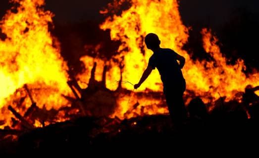 Europa; Deutschland; Osterbrauch: Kind wirft Äste in ein großes Osterfeuer *** Europe Germany Easter custom child throws branches into a big Easter fire