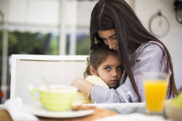 Mother embracing her sad daughter during breakfast at home model released Symbolfoto property released  ABZF02227