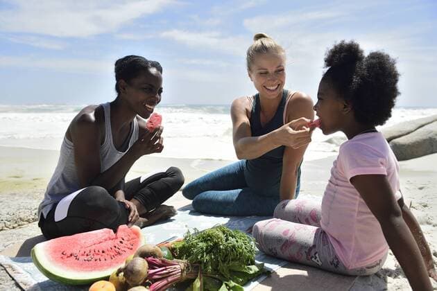 Mother with daughter and friend having a picnic on the beach model released Symbolfoto  ECPF00422