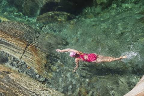 Switzerland, Ticino, Verzasca Valley, woman swimming in refreshing Verszasca river model released Symbolfoto  GWF05955