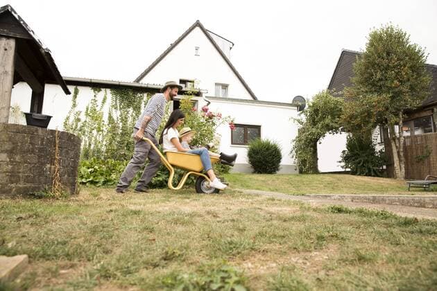 Playful man pushing wife and son sitting in wheelbarrow in garden model released Symbolfoto property released  MFRF01277