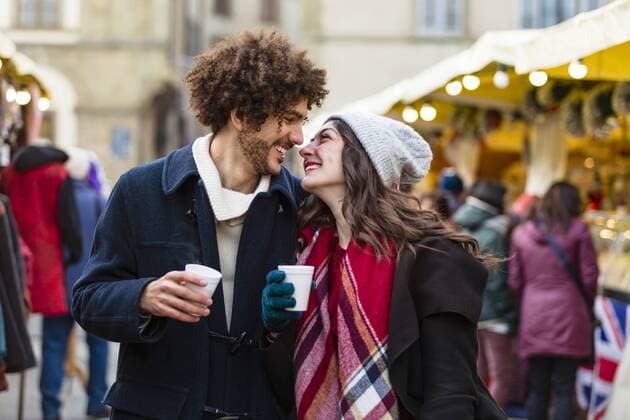 Happy affectionate young couple with hot drinks at Christmas market model released Symbolfoto  MGIF00310