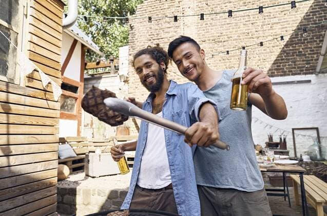 Friends preparing meat for a barbecue in the backyard model released Symbolfoto property released  PDF01813