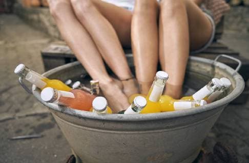 Friends relaxing in a backyard in summer, young women cooling their feet in a tub with drinks model released Symbolfoto property released  PDF01859