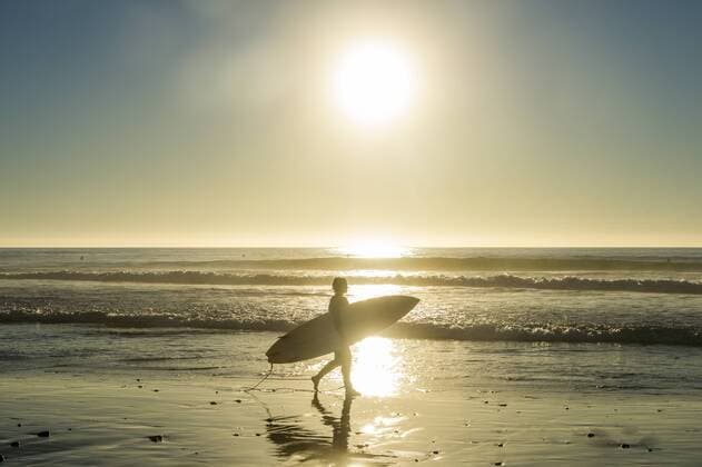 USA, California, Del Mar, Surfer at the beach against the sun model released Symbolfoto  RUNF01127