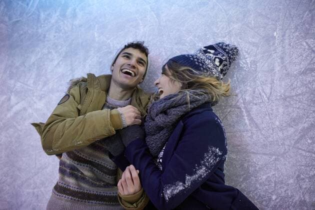 IMAGO Creative, Jahreszeit Winter, Eislaufen Laughing couple lying on an ice rink at night model released Symbolfoto property released  ZEDF01896