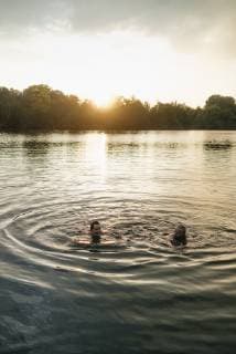 Old and young man swimming in a lake at sunset model released Symbolfoto  GUSF01825