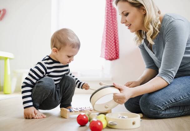 Mother and toddler son playing with musical instruments at home model released Symbolfoto property released  HAPF02832