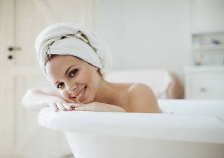 Portrait of smiling woman with towel around her head taking a bath at home model released Symbolfoto property released  HAPF02877