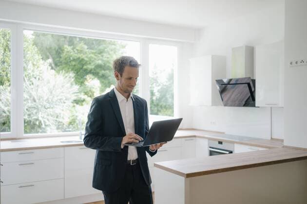 Businessman in newly refurbished home, using laptop in kitchen model released Symbolfoto property released  KNSF05464
