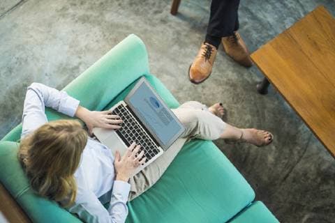 Top view of businesswoman working on laptop on turquoise couch in coworking space model released Symbolfoto property released  SBOF01556