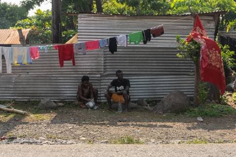 A man and woman sit underneath a clothes line in Tapachula, Mexico on May 9, 2019. Migrants from Africa and Haiti have temporarily settled near the (INM) Instituto Nacional de Migracion Delegacion Federal en Chiapas building while hoping to apply for an exit visa so they can make their way to the US-Mexico border.  TP2019050903 ARIANAxDREHSLER