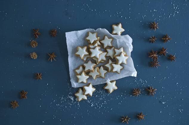 Cinnamon stars, star anise and pine cones on blue ground  ASF06356