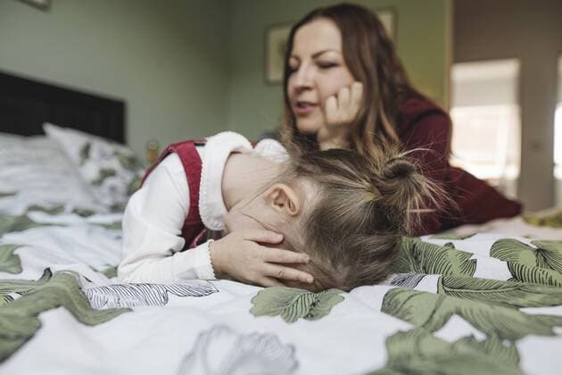 Mother and sad girl lying on bed model released Symbolfoto property released  KMKF00852