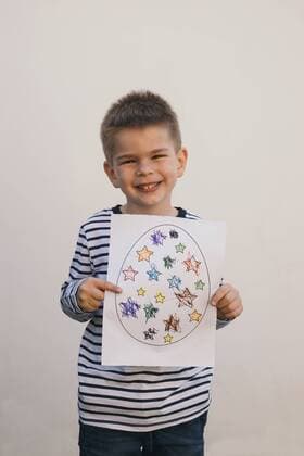 Boy holding his art work and smiling model released Symbolfoto property released  MOMF00680