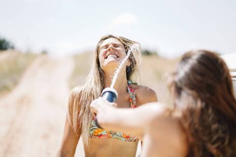 Two happy young women in bikini splashing water model released Symbolfoto  OCMF00360