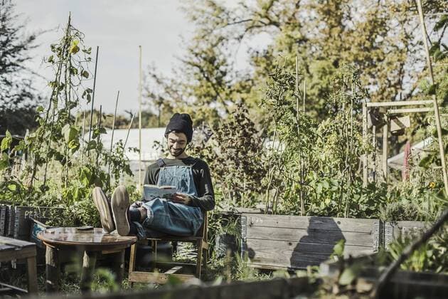 Smiling man reading book in urban garden model released Symbolfoto  VGPF00009