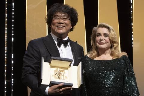 Bong Joon-ho with his Palme d Or (Golden Palm) for the movie Parasite Gisaengchung and Catherine Deneuve at the award ceremony during the 72nd Cannes Film Festival at the Palais des Festivals on May 25, 2019 in Cannes, France