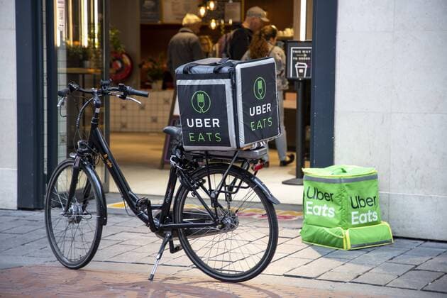 Amsterdam, Niederlande, Kuriere des Lebensmittel Online Lieferdienst Uber Eats, Fahrradlieferant und Lieferkurier zu Fuss,