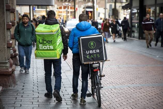 Amsterdam, Niederlande, Kuriere des Lebensmittel Online Lieferdienst Uber Eats, Fahrradlieferant und Lieferkurier zu Fuss,