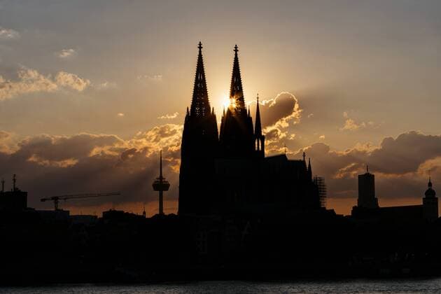 Die untergehende Sonne scheint zwischen den beiden Türmen des Kölner Dom hindurch. Köln, 30.05.2019