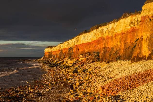 England, East of England Dramatic golden hour seascape of Hunstanton cliffs with dark stormy sky, on North Norfolk coast, Norfolk, East Anglia, England, United Kingdom, Europe Copyright: AndrewxMichael 1267-385