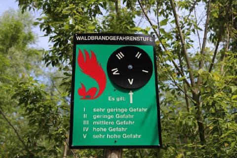 Ein Warnschild zeigt die aktuelle Waldbrandgefahrenstufe (V Sehr hohe Gefahr) in einem Wald bei Potsdam, 9. Juni 2019. Warnschild Waldbrandgefahr *** A warning sign shows the current forest fire hazard level V Very high hazard in a forest near Potsdam, 9 June 2019 Warning sign Forest fire hazard
