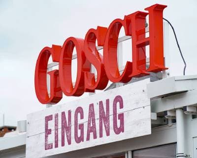 Jürgen Gosch erfolgreicher Inhaber, Unternehmer, Fischhänder und Visionär der gleichnamigen Marke Gosch an seinem Standort auf Sylt List in Kochjacke mit Firmenlogo. Sylt List Nordfriesland Deutschland