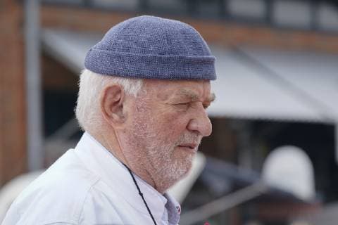 Jürgen Gosch erfolgreicher Inhaber, Unternehmer, Fischhänder und Visionär der gleichnamigen Marke Gosch an seinem Standort auf Sylt List in Kochjacke mit Firmenlogo. Sylt List Nordfriesland Deutschland