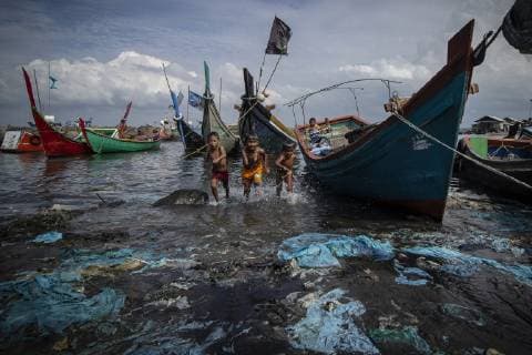 June 21, 2019 - Lhokseumawe, Aceh, Indonesia - Children play in the seawater contaminated with plastic pollution at the coastal areas in Lhokseumawe..From Greenpeace data, waste production in Indonesia reaches 65 million tons per year. Indonesia is the second largest country in the world for plastic waste production after China. At the 34th ASEAN Summit on June 20-23 2019 in Thailand, Indonesian president Joko Widodo will raise the issue of plastic waste that pollutes at the sea. Lhokseumawe Indonesia - ZUMAs197 20190621_zab_s197_002 Copyright: xZikrixMaulanax